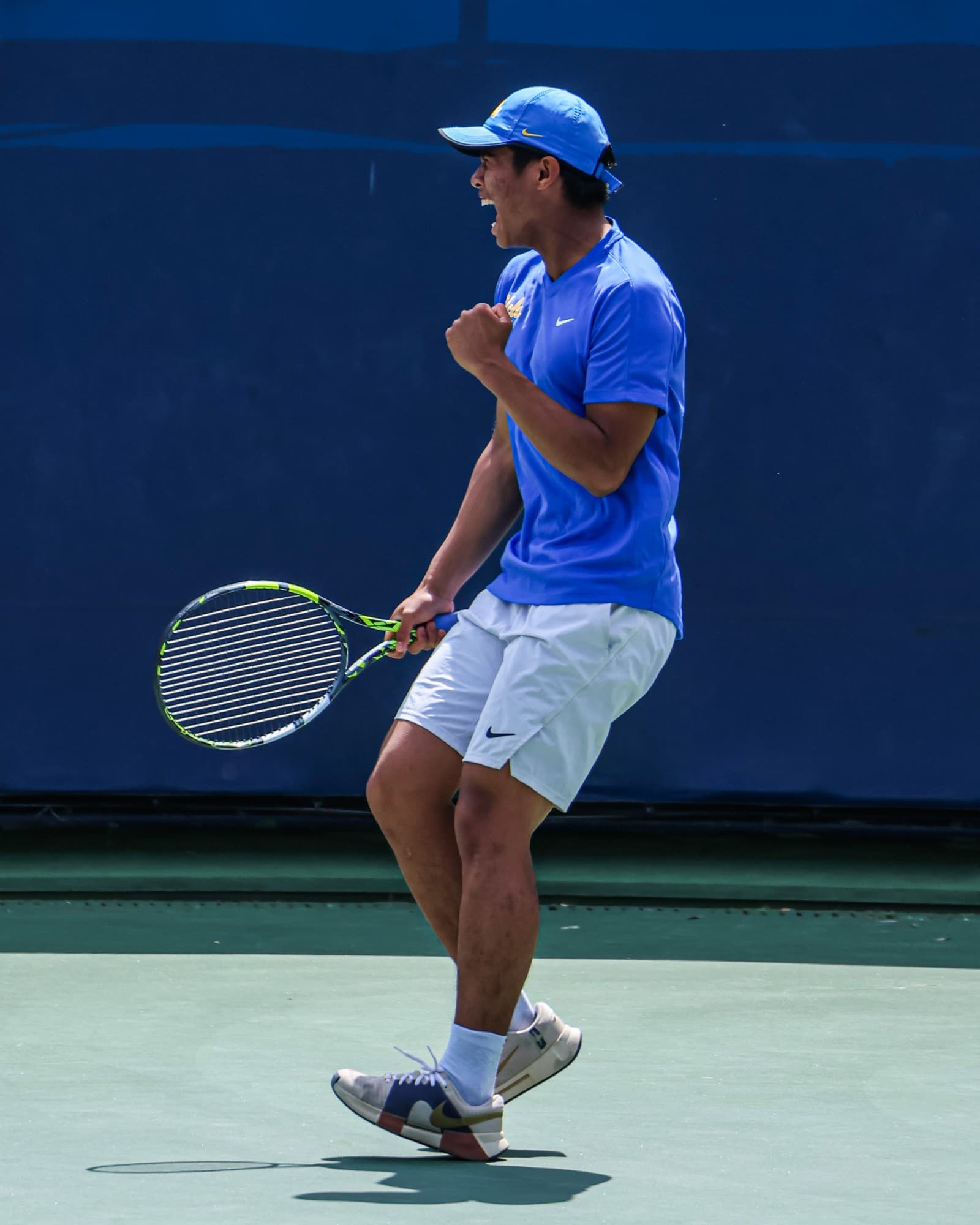 Rudy Quan of UCLA shouts and pumps a fist after winning a point.